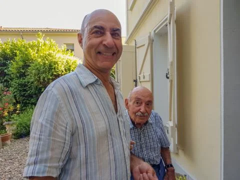 Portrait of two men. The elderly son supports his old father and helps his. Stock Photos
