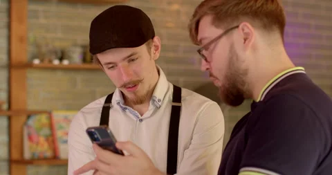 Portrait of two men talking with phone indoor. Lifestyle people discussing AI Stock Footage 248864840