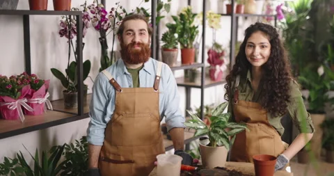 Portrait of two millennial florists working at flower shop. Greenhouse workers Stock Footage 155266833