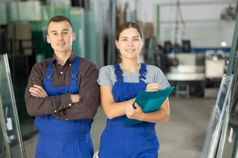 Portrait of two positive glaziers with folder of documents in glass workshop Stock-Fotos