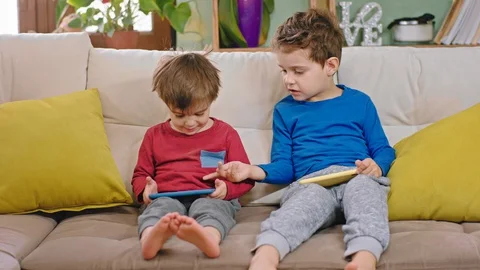 Portrait of a two small boys chatting funny together while using the smartphone Stock Footage 127704539