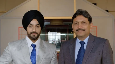 Portrait of two smart sharp Indian businessmen alternatively looking at the came Stock Footage 102548036