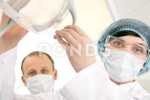 Portrait of two surgeons in masks looking at camera Stock Photos
