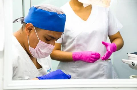 Portrait of two surgeons at work, operating in uniform, looking at the camera. Stock Photos