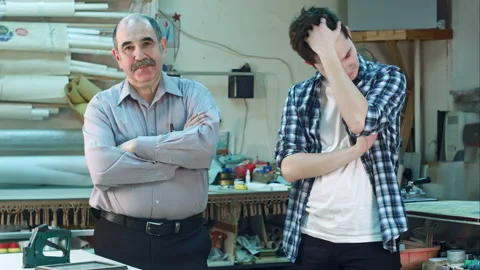 Portrait of two workers, standing in workshop and looking at camera seriously Vidéo 121343640