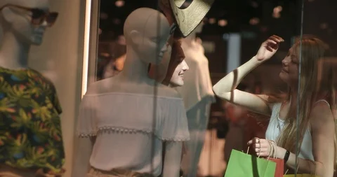 Portrait of two young and pretty women trying on a hat from the mannequin. Two Stock Footage 113403603