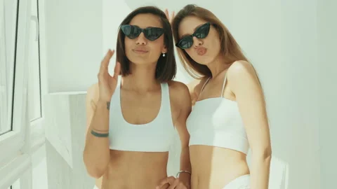 Portrait of two young beautiful smiling women in white lingerie Stock Footage 142419112
