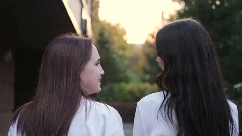 Portrait of two young beautiful smiling teenage girls posing against the Stock Footage 230979668