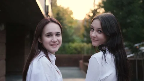 Portrait of two young beautiful smiling teenage girls posing against the Stock Footage 231035013