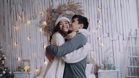 Portrait of two young lovers inside, warmly embracing around Christmas. Stock Footage 142735108