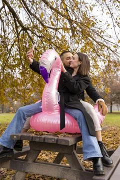 Portrait of two young lovers taking a selfie having fun riding an inflatabl.. Stock Photos