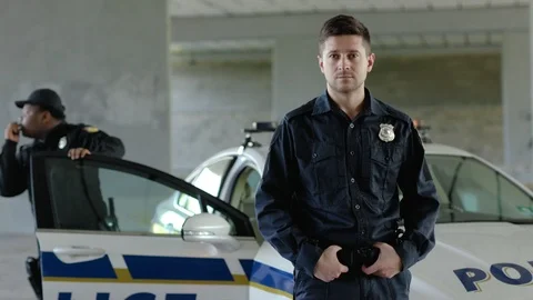 Portrait two young man cops stand near patrol car look at camera background Stock Footage 112958361