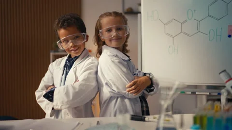 Portrait of two young scientists in lab coats posing on camera, fun science Stock Footage 277899225