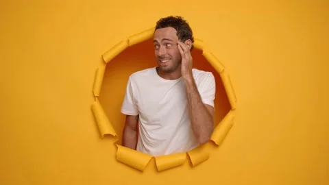 Portrait of uncertain caucasian man standing over yellow torn background unsure Stock Footage 233346541