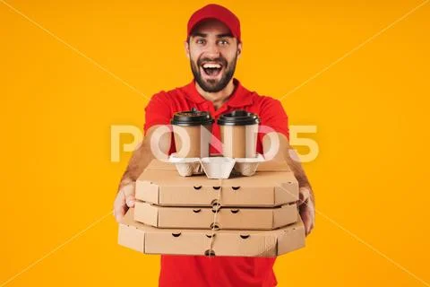 Portrait of unshaven delivery man in red uniform holding pizza boxes and take Stock Photos