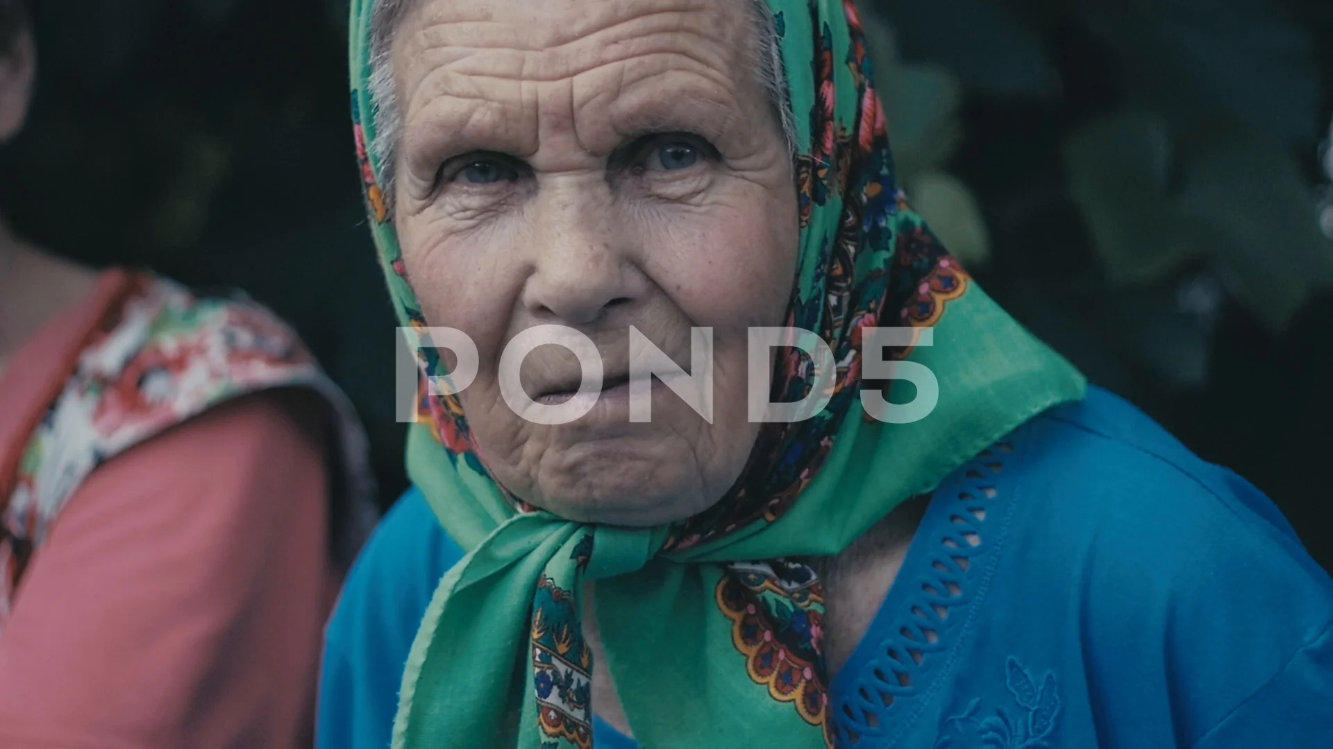 Portrait of Very old woman alone in a scarf at garden outdoor