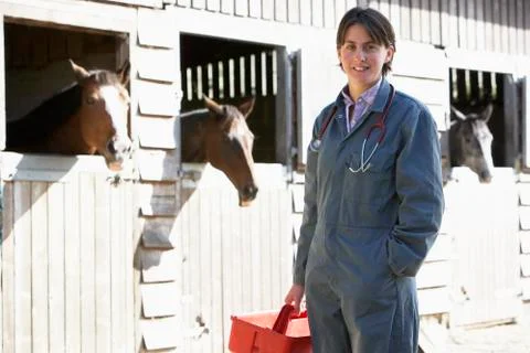 Portrait Of Vet Standing By Horse Stables Stock Photos