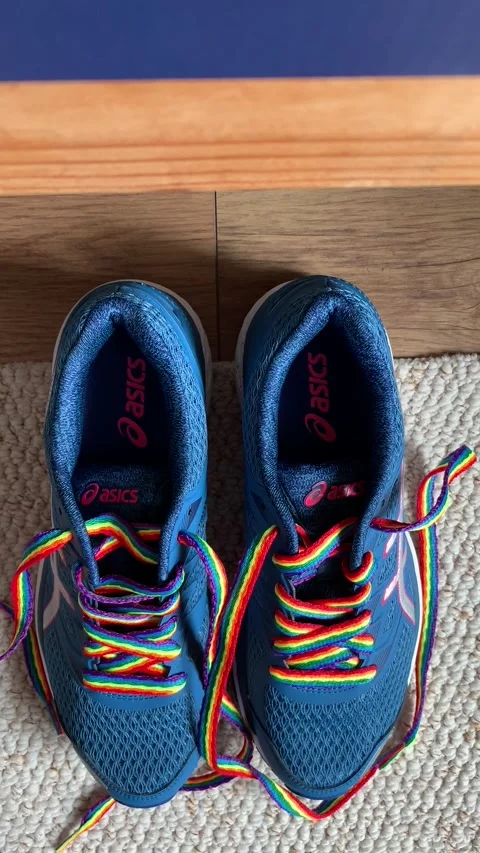 Portrait video of running trainers changing to rainbow pride shoe laces 1080p Stock Footage 244010045