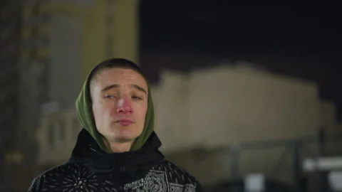 Portrait view of boy in winter jacket and hoodie walking alone at dusk Stock Footage 316453324