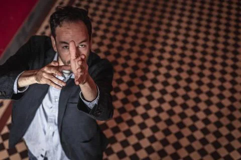 Portrait view of an handsome guy dancing alone in a red hallway wearing a cas Stock-Fotos