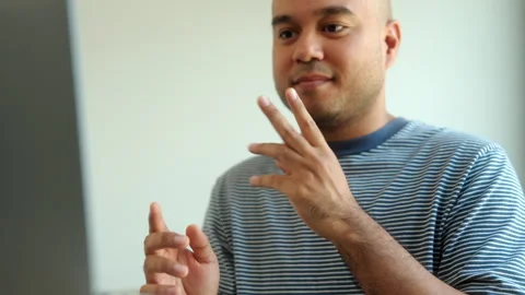 Portrait view of happy young deaf asian man showing sign language and looking at Video stock 299868032