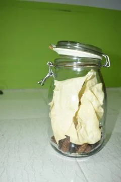 Portrait view a transparent jar inside fry poppadum in green and white backgr Stock Photos