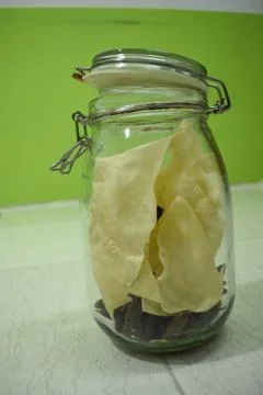 Portrait view a transparent jar inside fry poppadum in green and white backgr Stock Photos