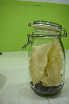 Portrait view a transparent jar inside fry poppadum in green and white backgr Stock Photos