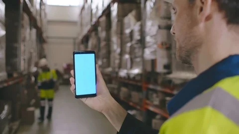 Portrait of warehouse employees using smartphone and working in storehouse Stock Footage 123277857