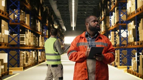 Portrait of warehouse worker overseeing pallets details on tablet Stock Footage 332907186