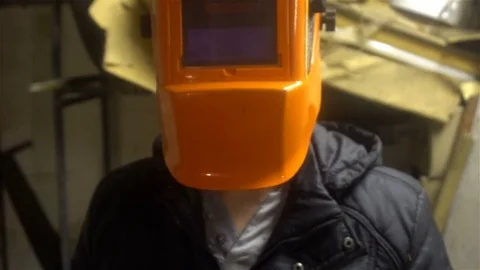 Portrait of a welder standing in front of the camera in an orange mask 4k Stock Footage 83314019