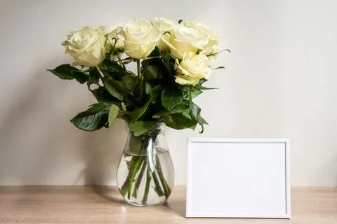 Portrait white frame mockup on table.Modern vase with rosesScandinavian interior Stock Photos