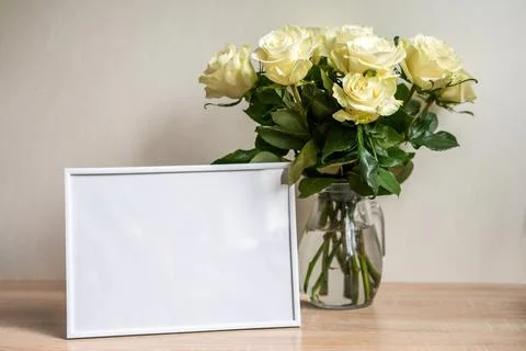 Portrait white frame mockup on table.Modern vase with rosesScandinavian interior Stock Photos