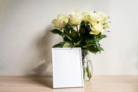 Portrait white frame mockup on table.Modern vase with rosesScandinavian interior Stock Photos