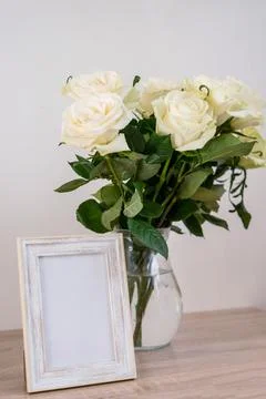 Portrait white frame mockup on table.Modern vase with rosesScandinavian interior Stock Photos
