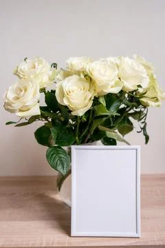 Portrait white frame mockup on table.Modern vase with rosesScandinavian interior Stock Photos