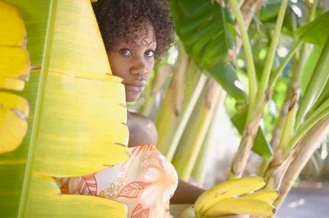 Portrait of woman in banana tree holding bananas Stock Photos