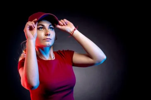 Portrait of a woman in a baseball cap on a black background. red and blue color Stock Photos