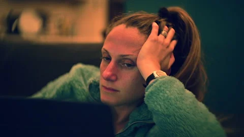 Portrait of a woman bored at the computer looking at the camera Stock Footage