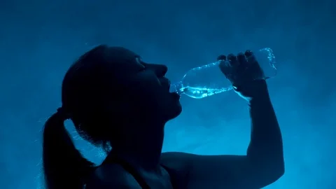 Portrait of woman drinks water from transparent bottle Stock Footage