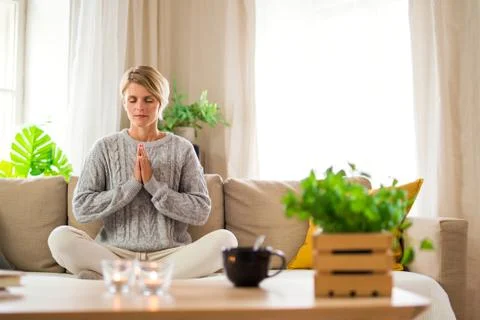 Portrait of woman indoors at home doing yoga, mental health and meditation Stock Photos