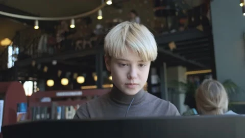 Portrait of a woman looking at a laptop while sitting in a cafe Video stock 153047713
