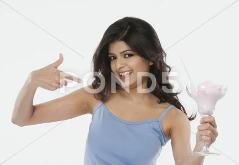 Portrait of a woman pointing towards an ice cream and smiling Stock Photos