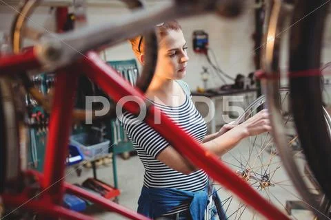 Portrait of woman repairing a wheel Stock Photos