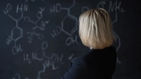 Portrait of a woman solving a difficult task, standing near the Board with Stock Footage 91206558