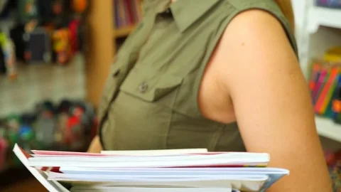 Portrait of a woman standing in library. Bookcase bookshelves in background. 4k Stock Footage
