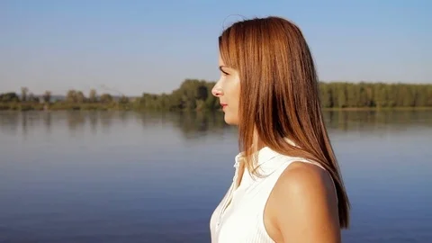 Portrait woman standing on the river shore. portrait of smiling woman on the Stock Footage