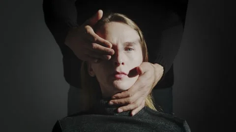Portrait of a woman whose face is brightly lit. The man covers her eyes with his Stock Footage 232997838