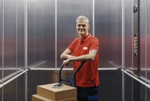 Portrait of a worker carrying boxes in the elevator Stock Photos
