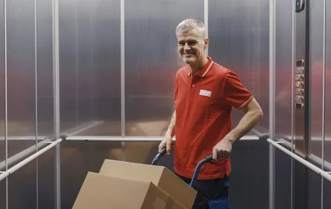 Portrait of a worker carrying boxes in the elevator Stock Photos